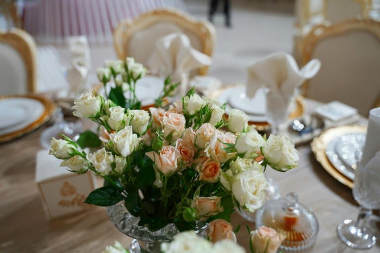 A beautifully arranged bouquet of roses enhances an elegant table setting, perfect for special occasions.